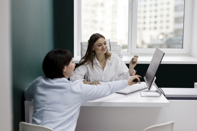 Zwei Frauen checken aktuelle Gesetzeslage am Computerbildschirm