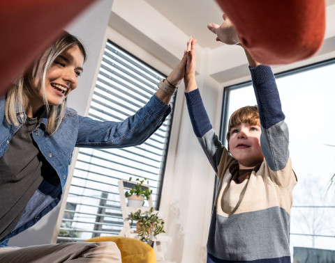 Bei einer Besichtigung werden Ideen geweckt. Vater, Mutter und Sohn klatschen die Hände in der Luft zusammen.